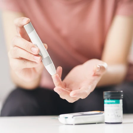 Person pricking their finger to check their blood sugar levels.