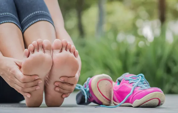 A person sitting down holding their feet.