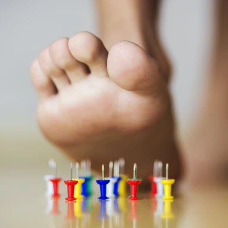 Foot over tacks.