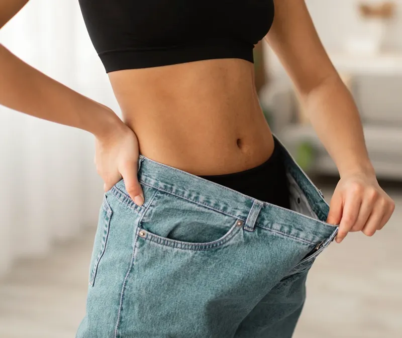 Weight Loss Baltimore MD Weight Loss Person wearing their old pants that are too big on them.