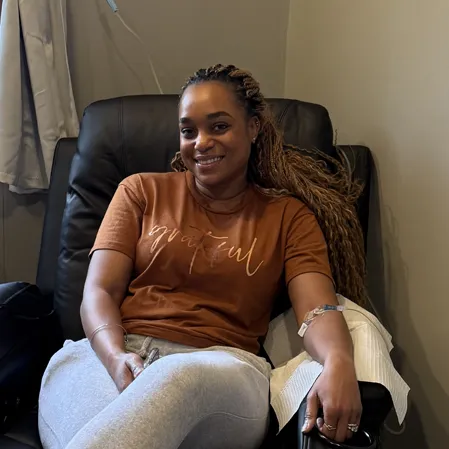 A patient sitting in a chair with an IV in their arm.