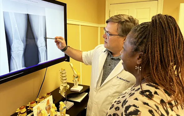 Dr. Michael Dorn explaining an X-ray to a patient.